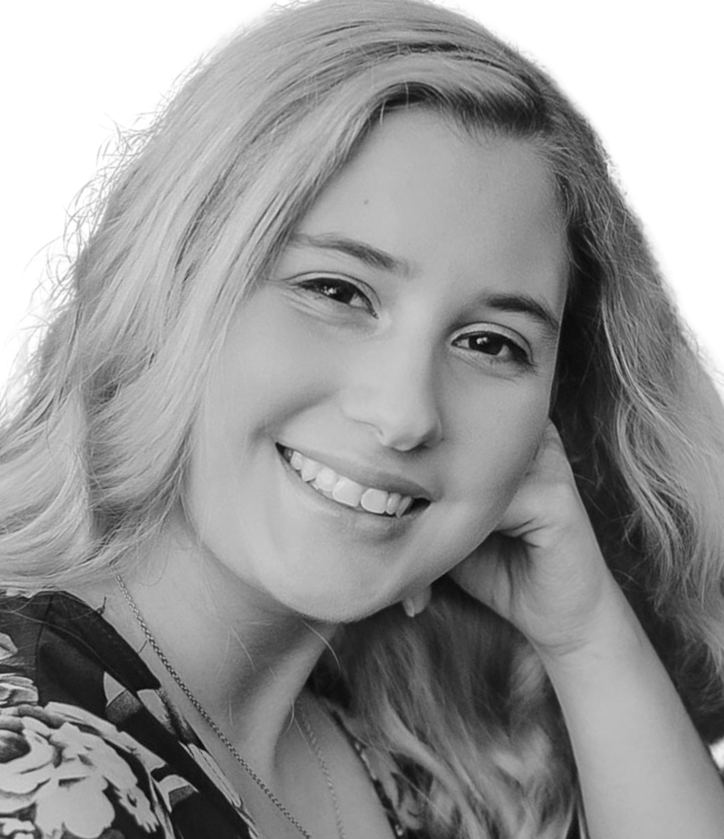 Smiling woman with wavy hair resting her head on her hand.