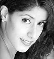 Black-and-white close-up portrait of a smiling woman with dark hair and direct eye contact