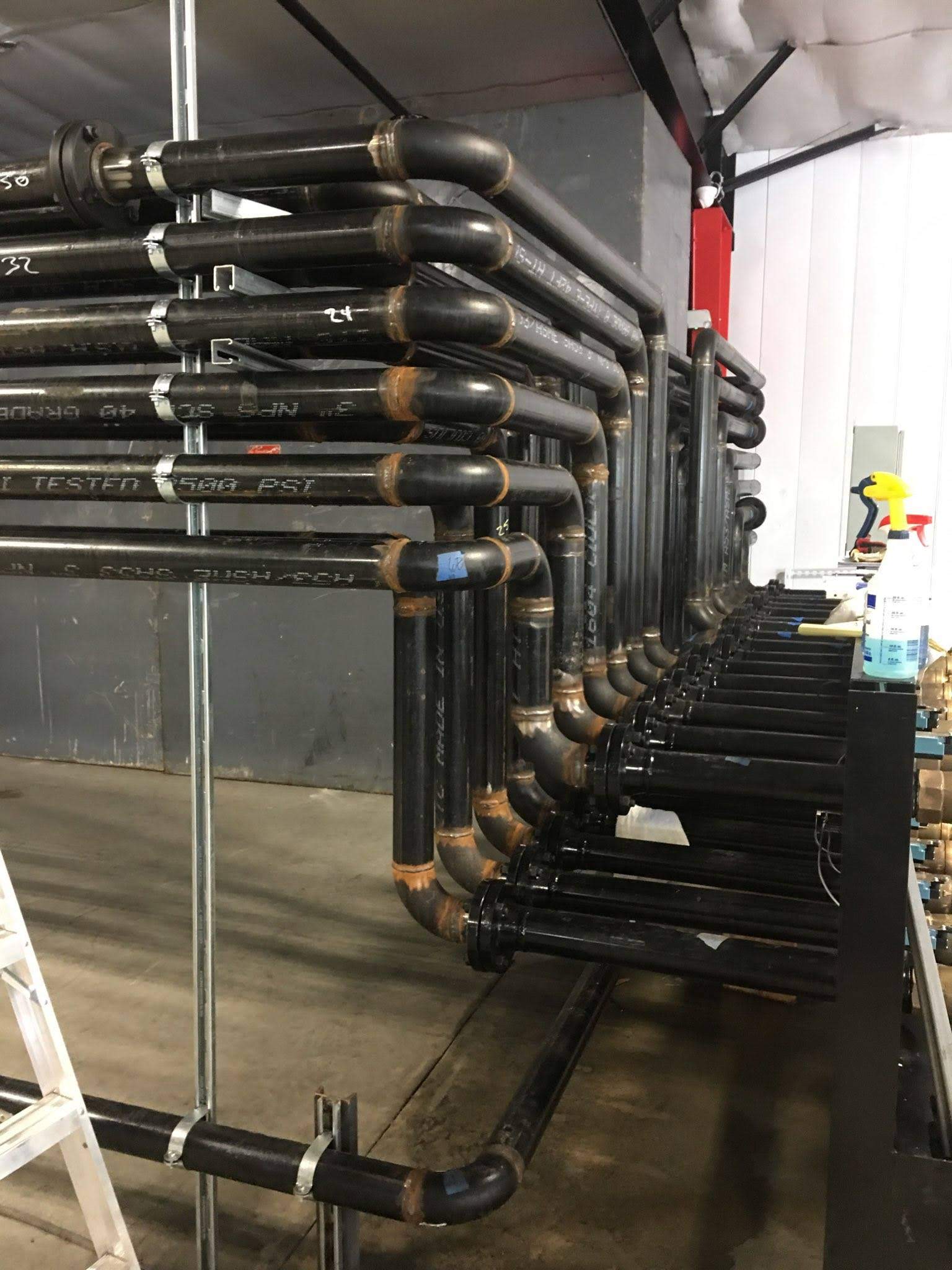 A bunch of pipes are stacked on top of each other in a room.