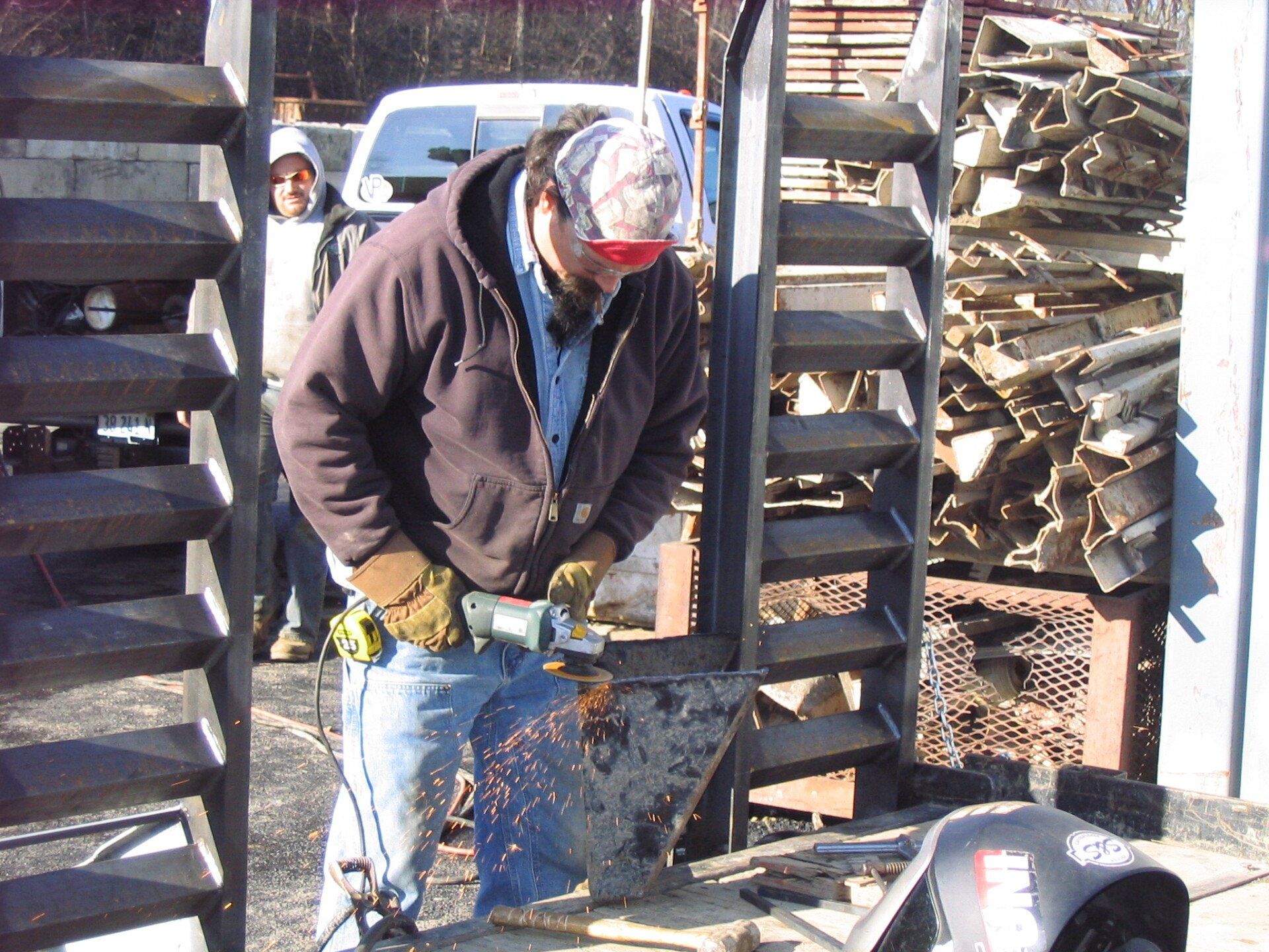A man is using a grinder to cut a piece of metal