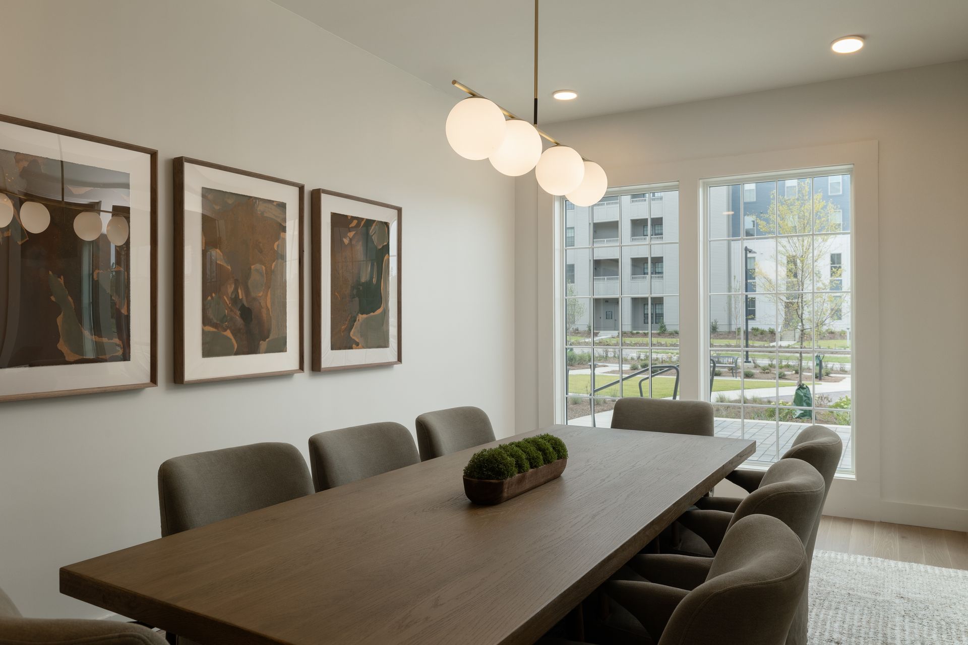 Conference room with a long table, chairs, art, and a large window.