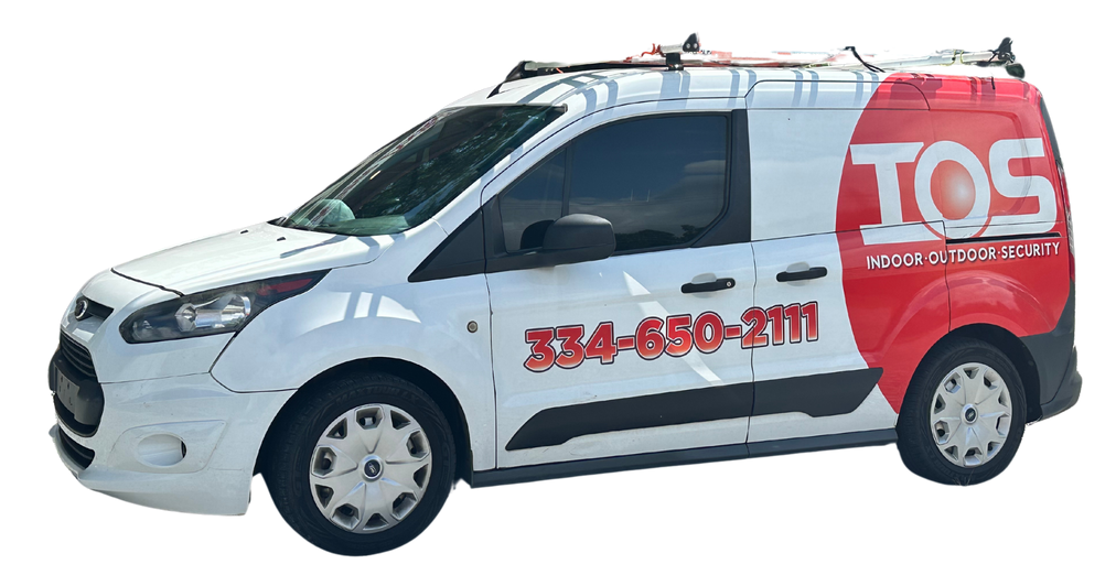 A white van in Columbus Ga with the word indoor outdoor security on the side is parked on a white background.