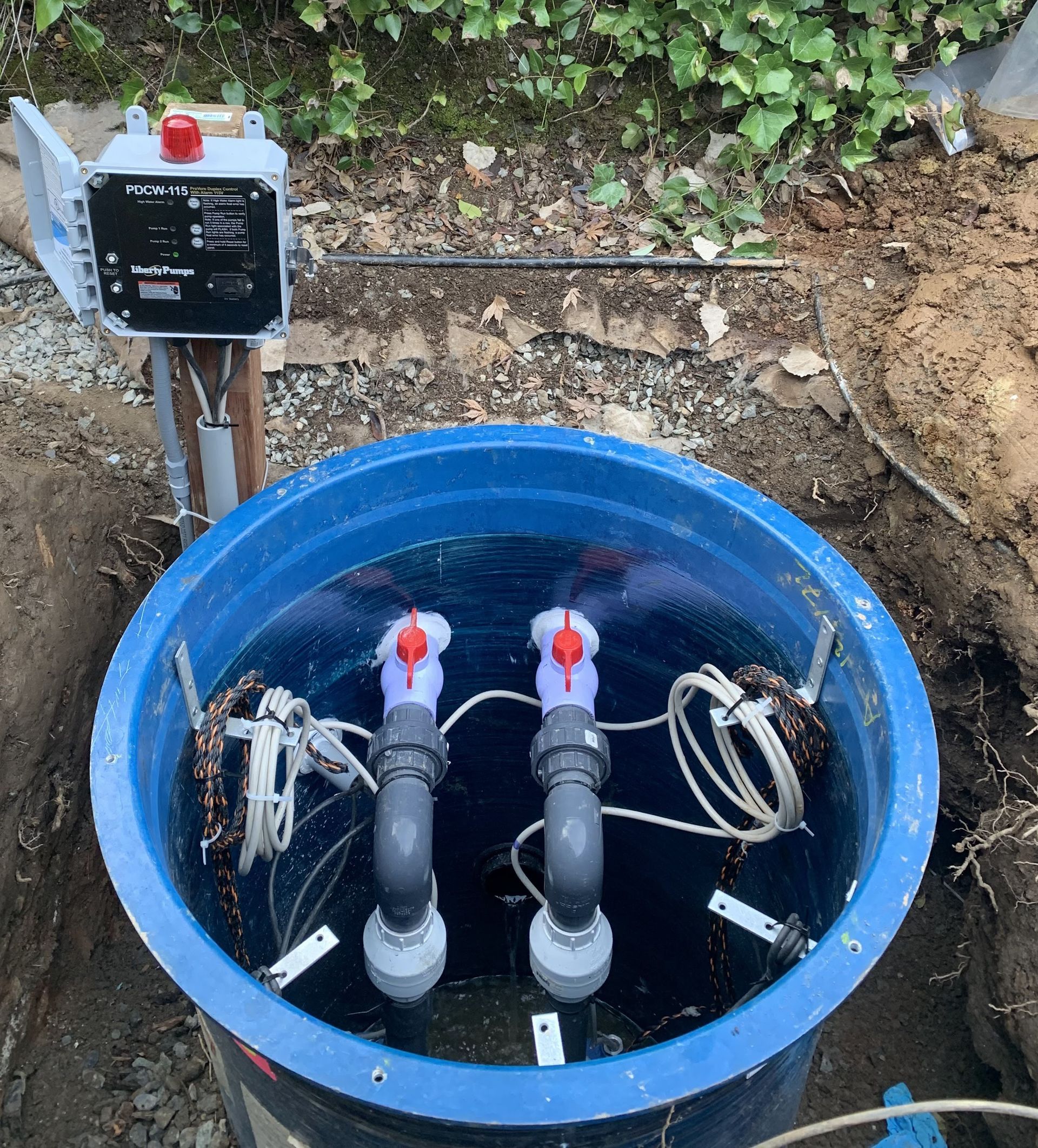 Rightway Plumbing Sewer And Drain - A blue bucket filled with water and pipes is sitting in the dirt.
