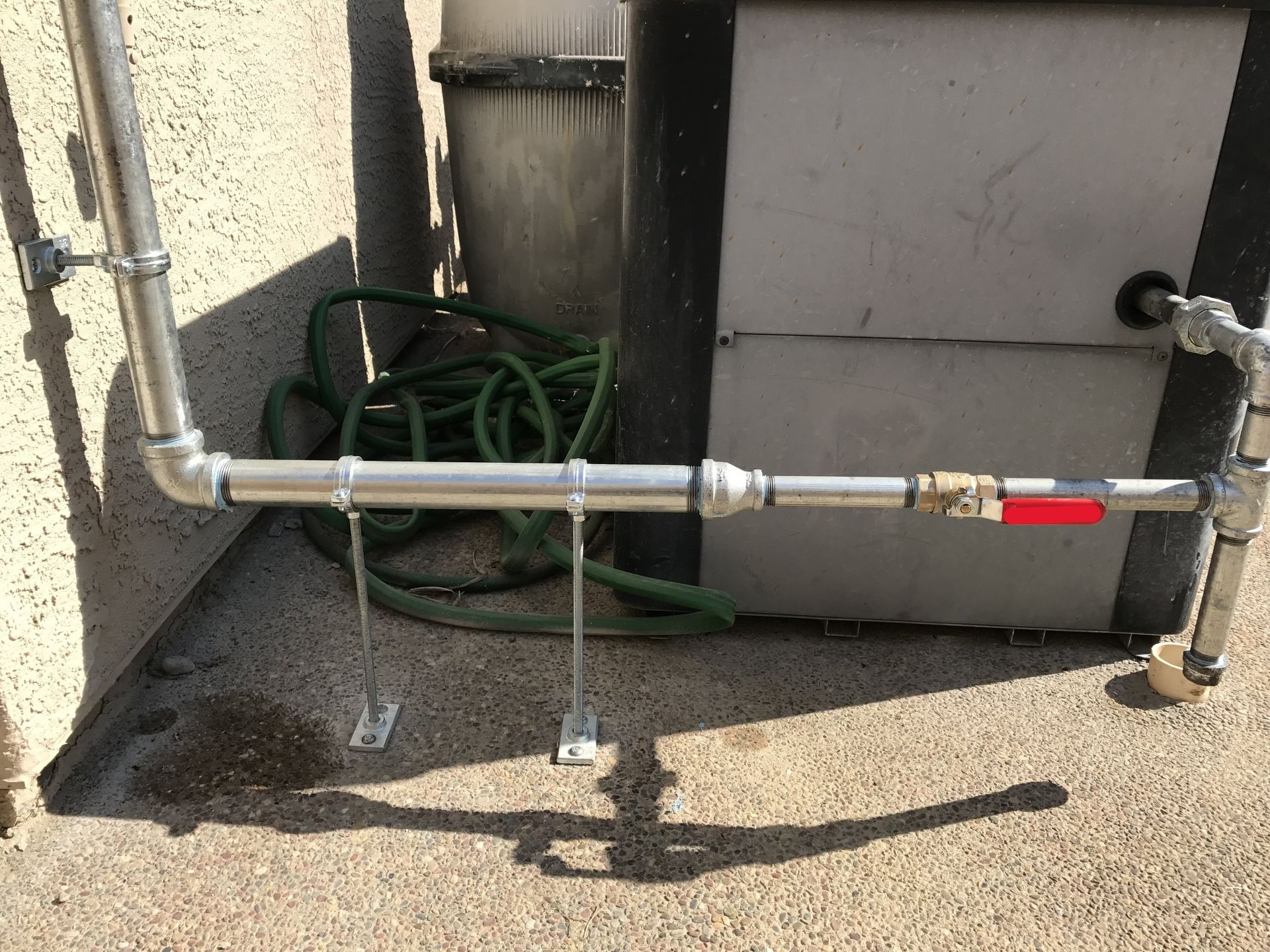 Rightway Plumbing Sewer And Drain - A hose is attached to a pipe outside of a building