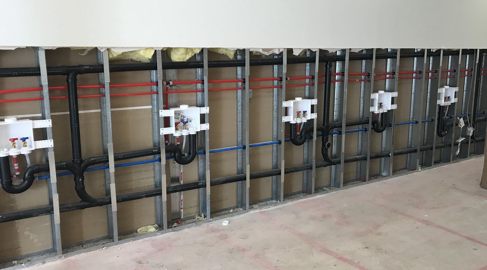 Rightway Plumbing Sewer And Drain - A row of pipes hanging on a wall in a room.