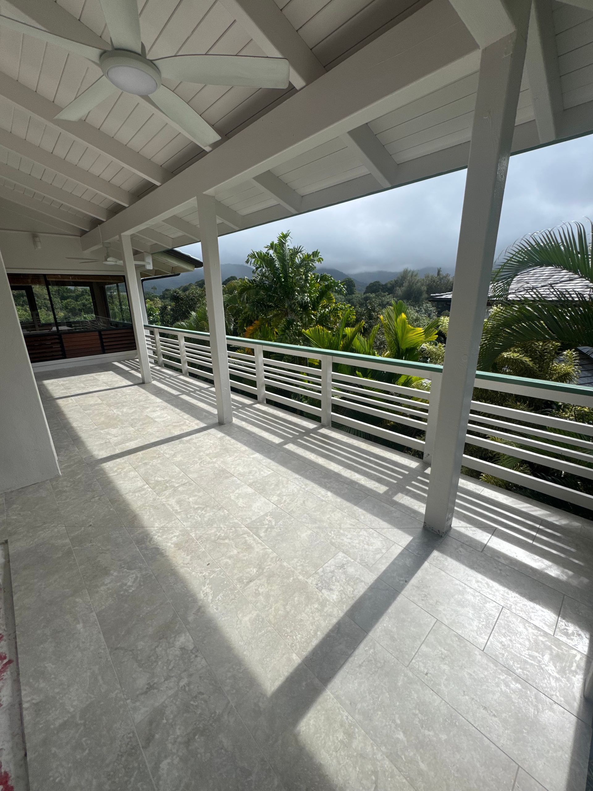 Covered outdoor patio with a view of trees and mountains.
