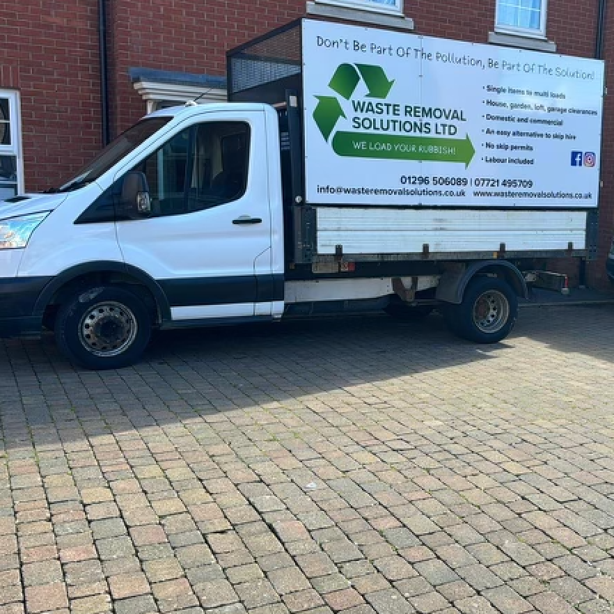 White Waste Removal Solutions truck parked on brick. Sign on side.