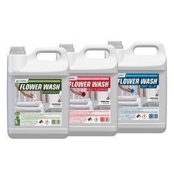 Tres envases de detergente Flower Wash con etiquetas verdes, rojas y azules sobre un fondo blanco.