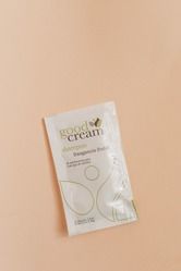 Sobre blanco de crema alimenticia para el cuidado de la piel sobre un fondo color melocotón