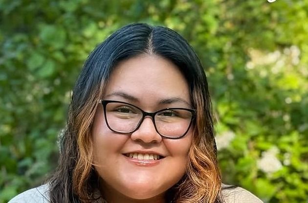 Jaileene, stylist at Whip Salon South Windsor, smiling outdoors in glasses