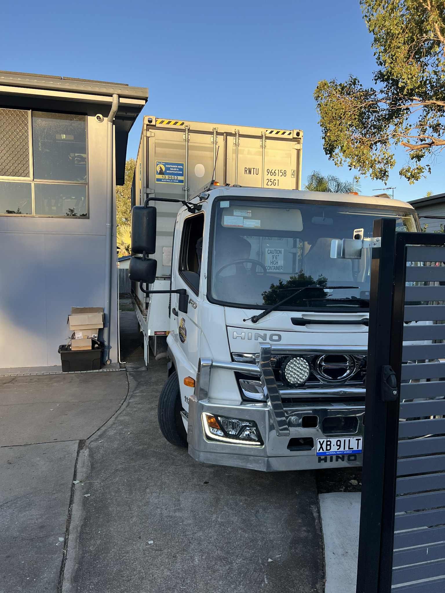 White Hino Truck With a Container on Its Flatbed Parked  — Rockhampton Container Sales in Kawana, QLD