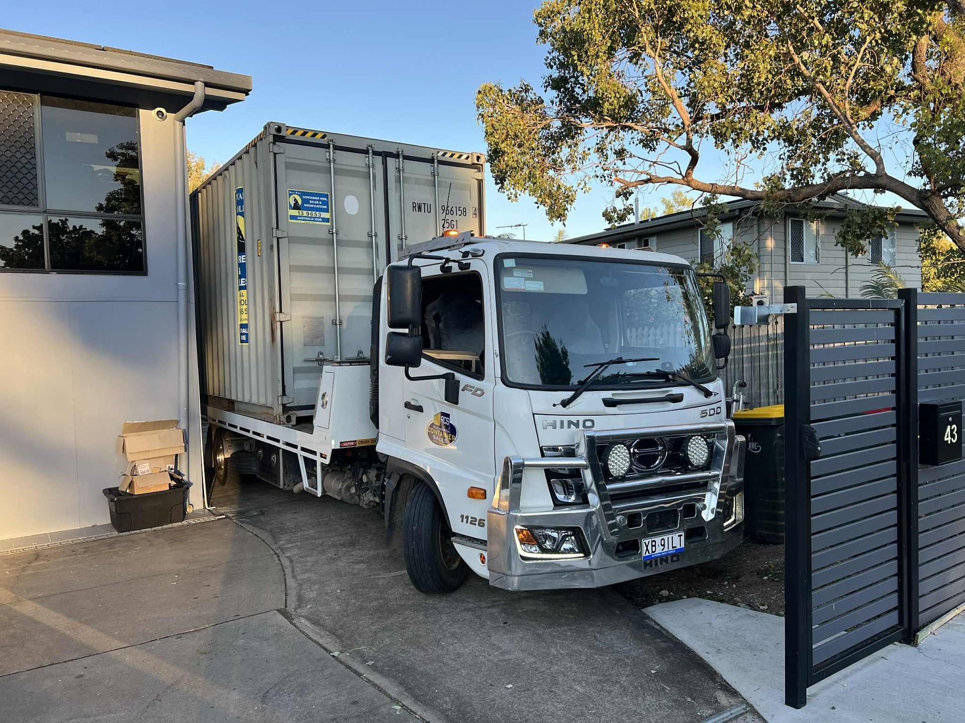 a Truck Carrying a Shipping Container Parked in a Residential Driveway  — Rockhampton Container Sales in Kawana, QLD