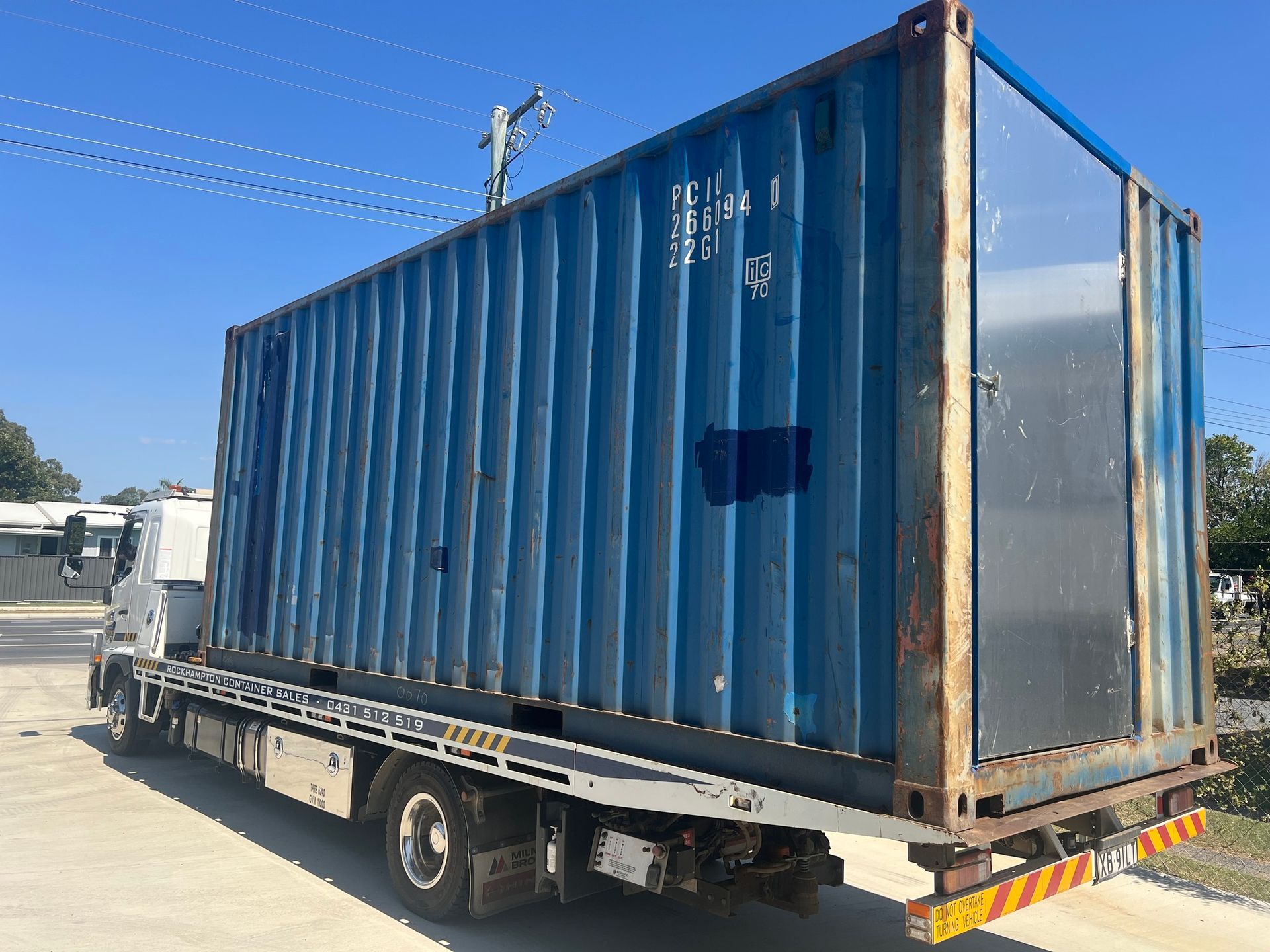Blue Shipping Container Loaded on a Flatbed Truck Outdoors on a Sunny Day — Rockhampton Container Sales in Kawana, QLD