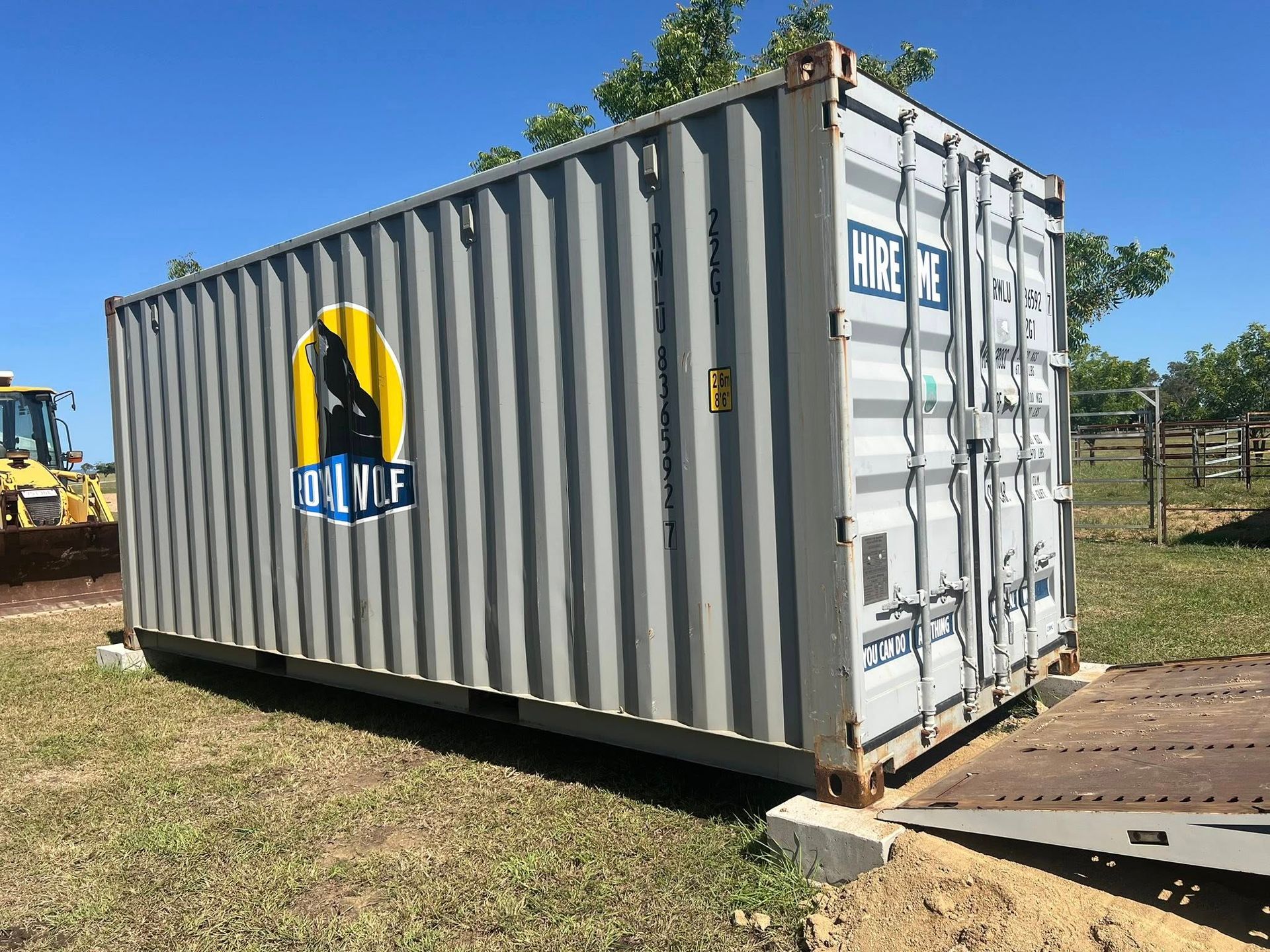 Gray Shipping Container With a Company Logo in a Grassy Field  — Rockhampton Container Sales in Kawana, QLD