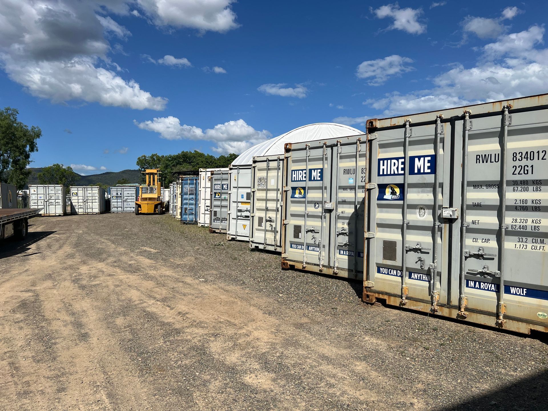 Beige Shipping Container Outdoors, Next to Other Containers, Under a Cloudy Sky — Rockhampton Container Sales in Kawana, QLD