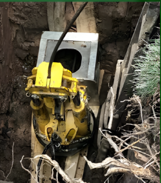 Red dump truck and yellow excavator working in a muddy construction site.