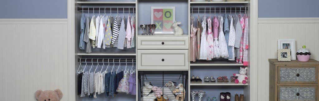 A child 's closet filled with clothes and a teddy bear.