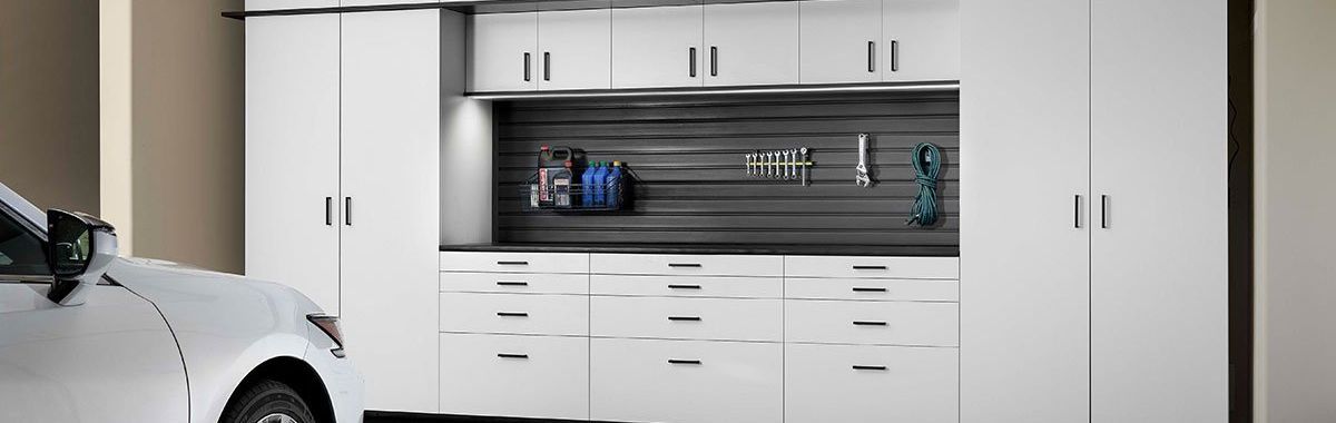 White garage storage cabinets and a car.