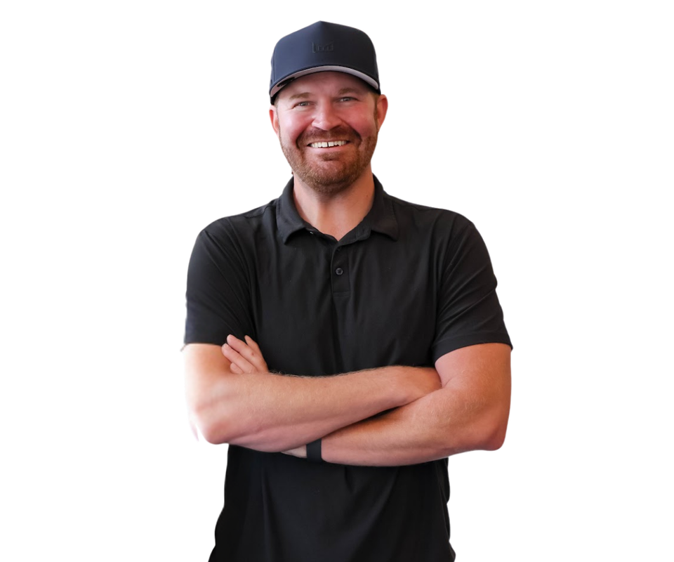 A man in a black polo shirt is standing with his arms outstretched