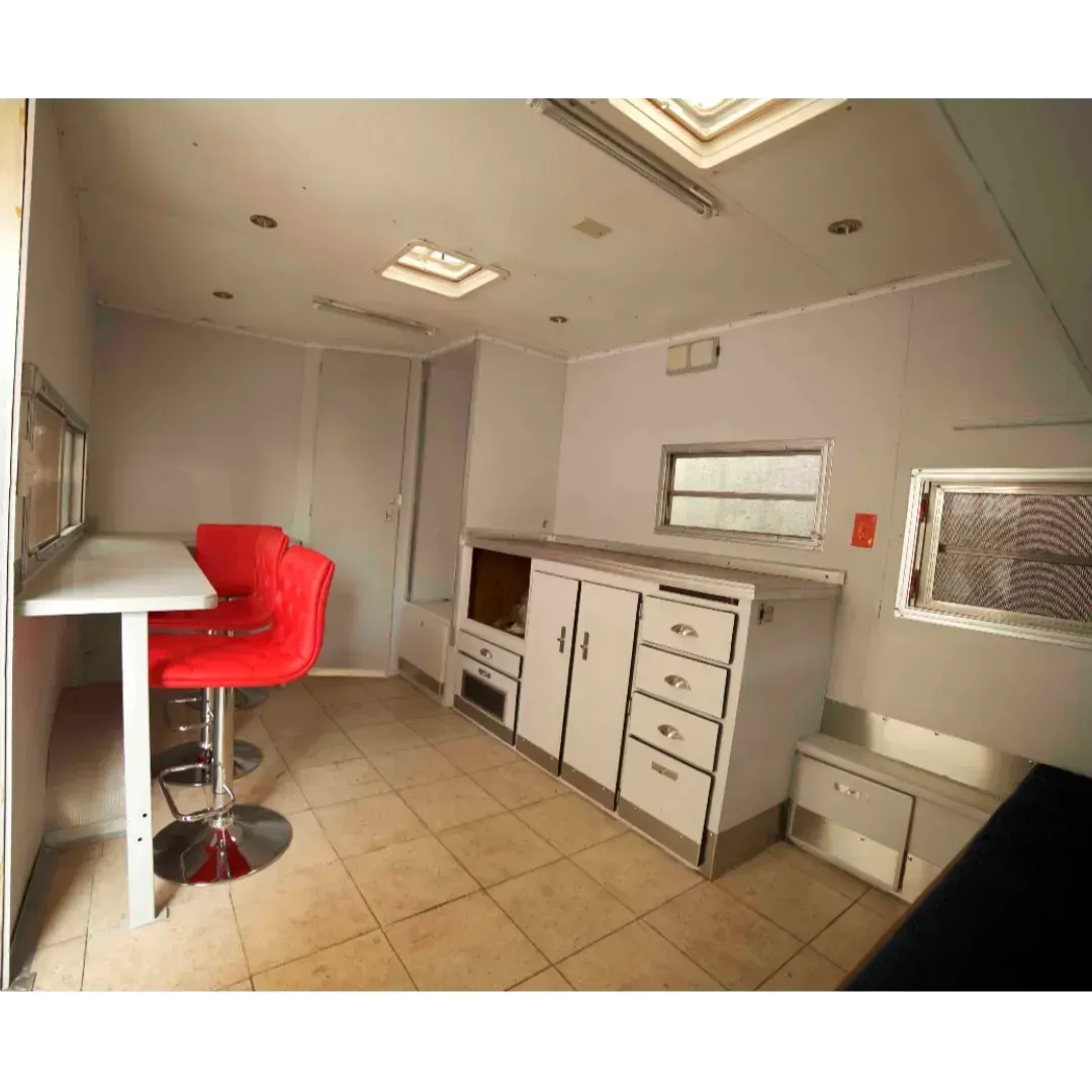 Una cocina con gabinetes blancos y sillas rojas.