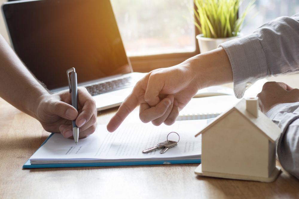 Person Signing Document, Another Person Points at the Paper — Property Transfer Professionals In Wyong, NSW