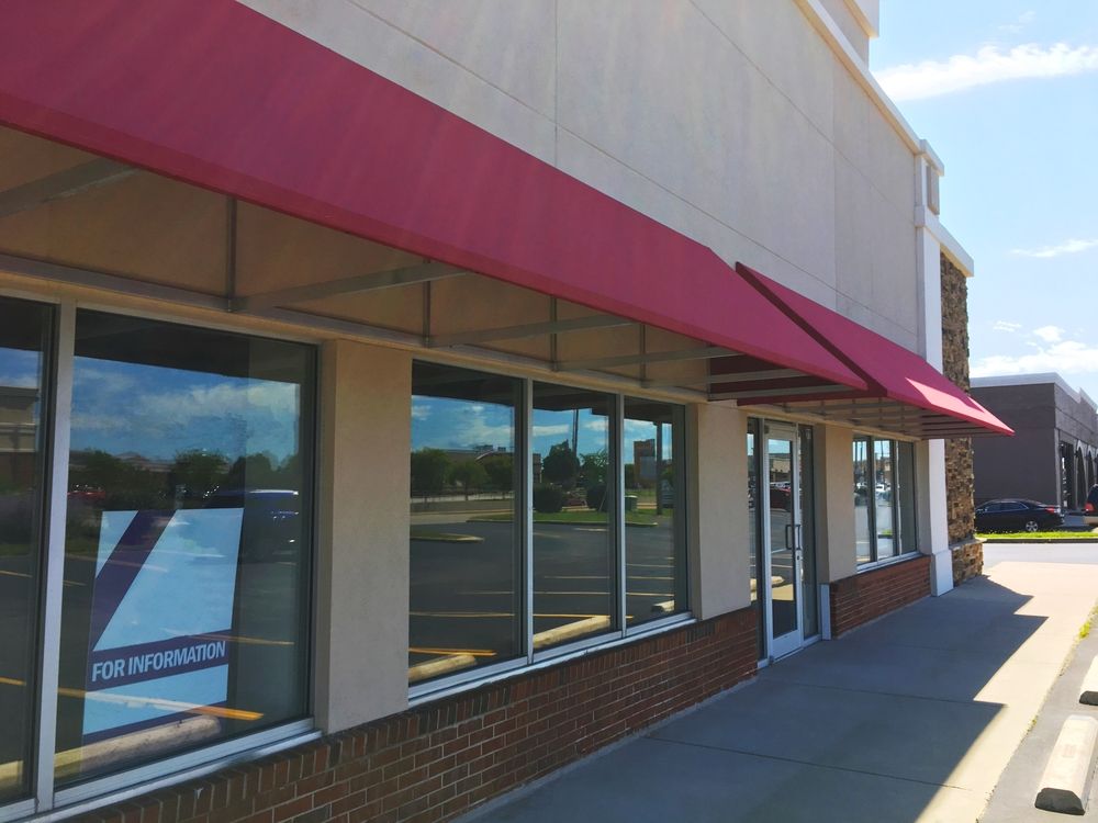 Exterior of a Commercial Building With a Red Awning Over Windows — Property Transfer Professionals In Wyong, NSW