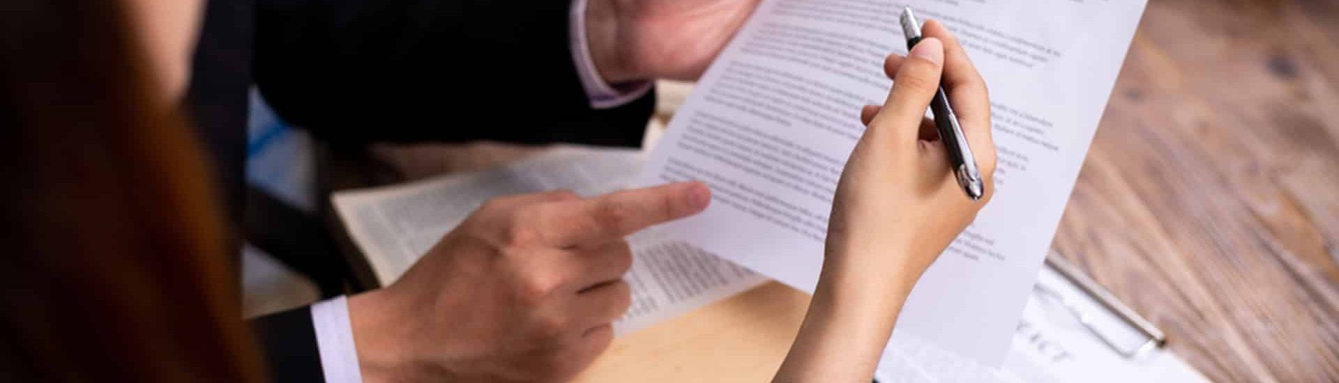 Hands Pointing at and Writing on a Document — Property Transfer Professionals In Wyong, NSW