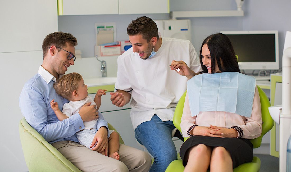 Getting established with a family dentist is beneficial for all. Pediatric and adult dentistry, male dentist showing little boy how easy it is to get teeth cleaned.