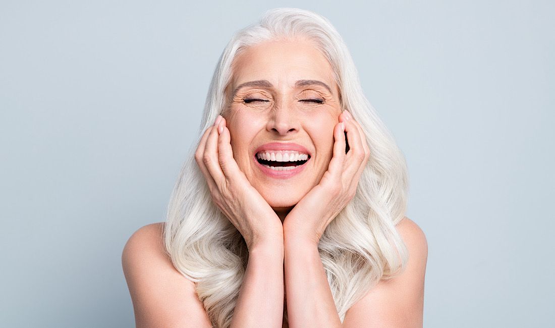 elderly, retired woman showing off her new smile after getting affordable dental implants