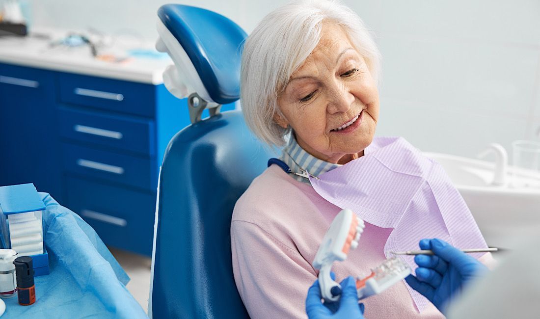 Elderly retiree consulting a dentist about dental implants in Salinas, CA.