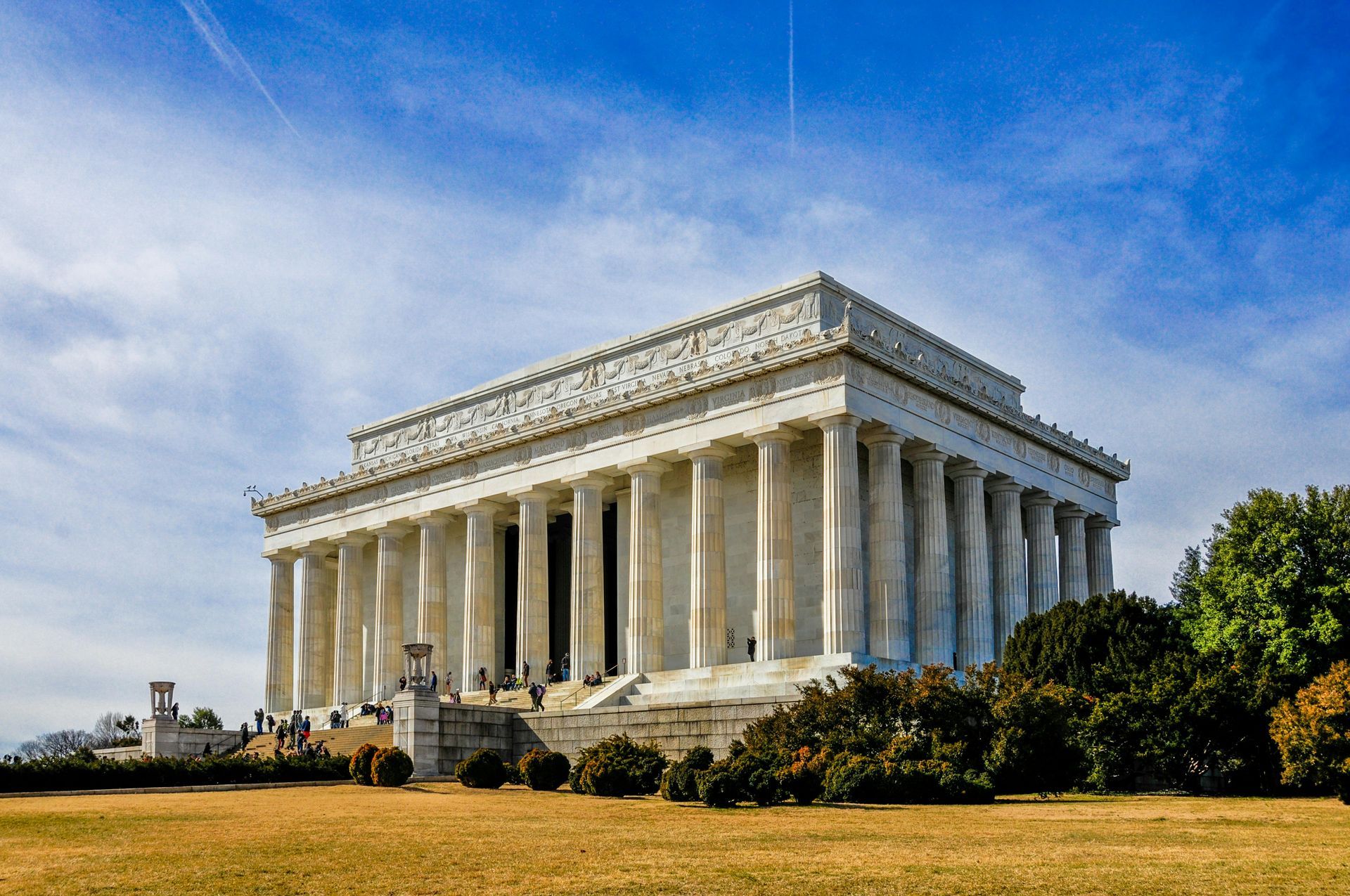 The Lincoln Memorial in Washington, D.C., under a blue sky, with a grassy foreground.