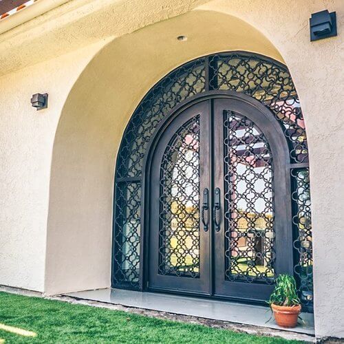 The front door of a house has a wrought iron design on it