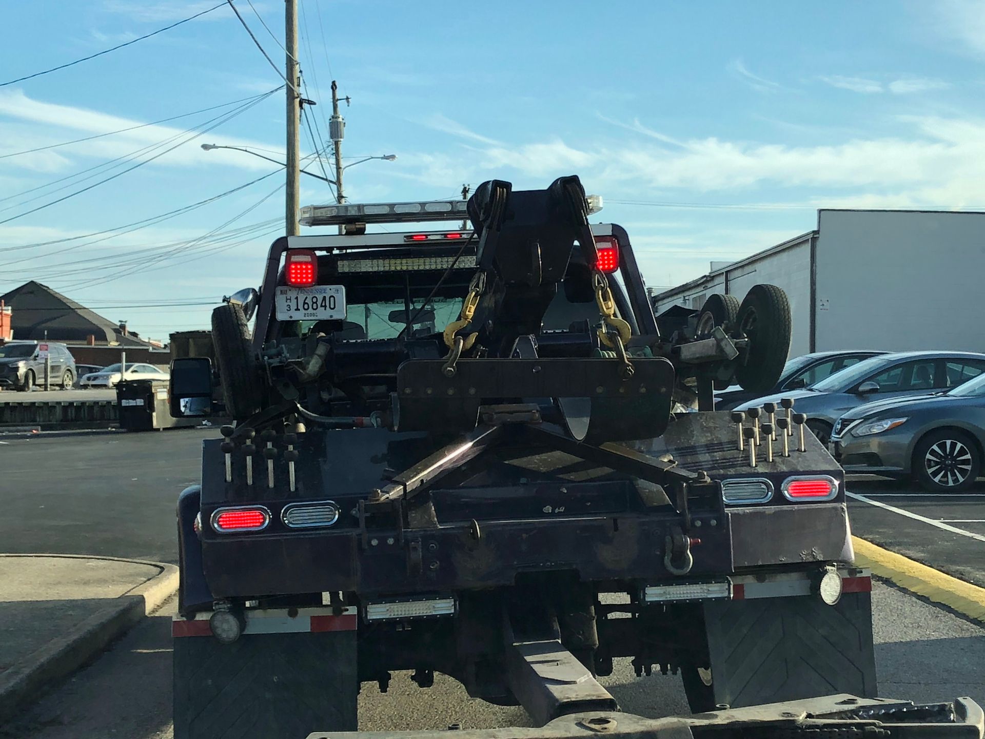 A tow truck is parked in a parking lot