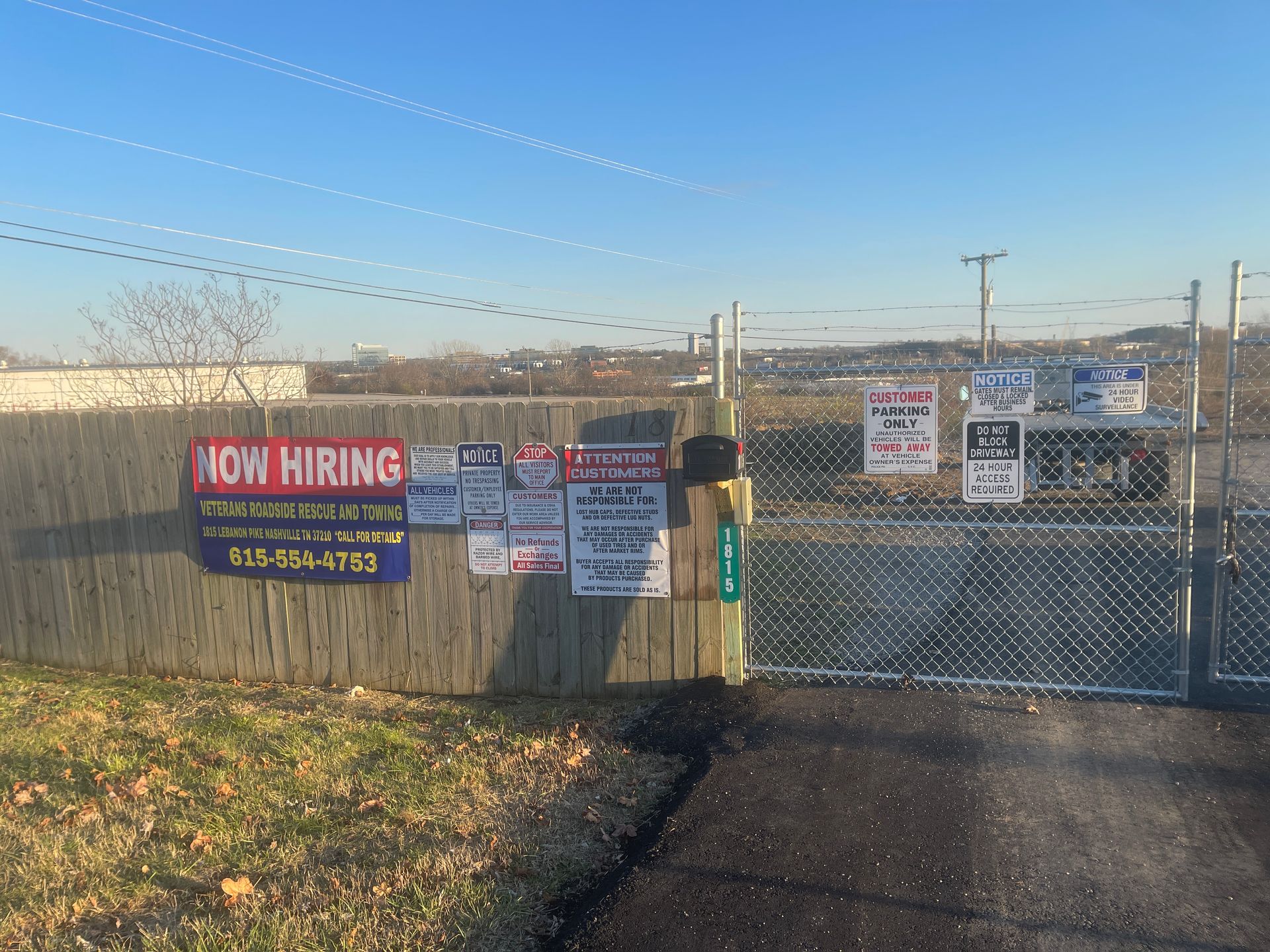 A fence with a sign that says now hiring on it