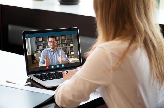 A woman is having a video call with a man on a laptop.