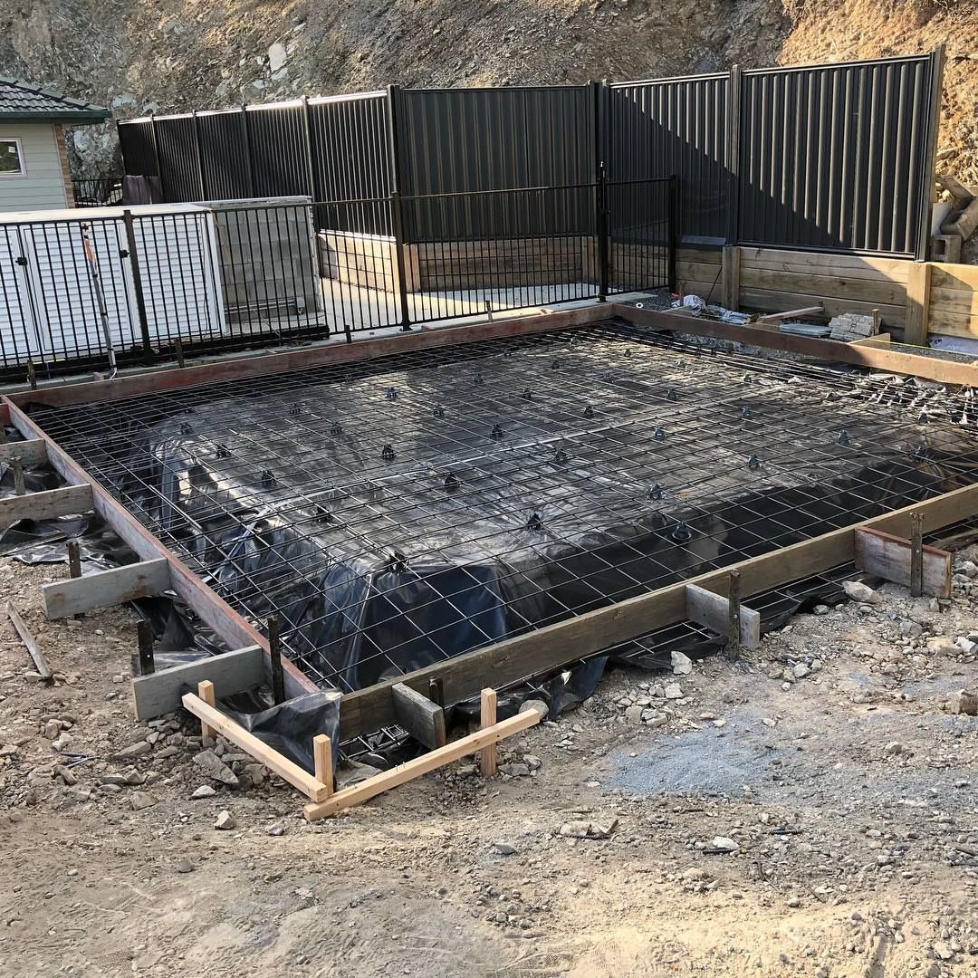 A construction site showing a concrete foundation formwork with rebar reinforcement and plastic vapor barrier. — Sand & Stone in Worongary, QLD