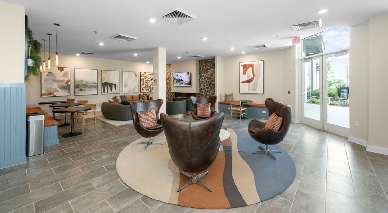 Spacious lobby with seating areas, artwork, and large windows. Includes round rug, leather chairs and tables. We invite you to visit 1001 Tyvola and take a tour of our apartments near Charlotte Douglas International Airport. 