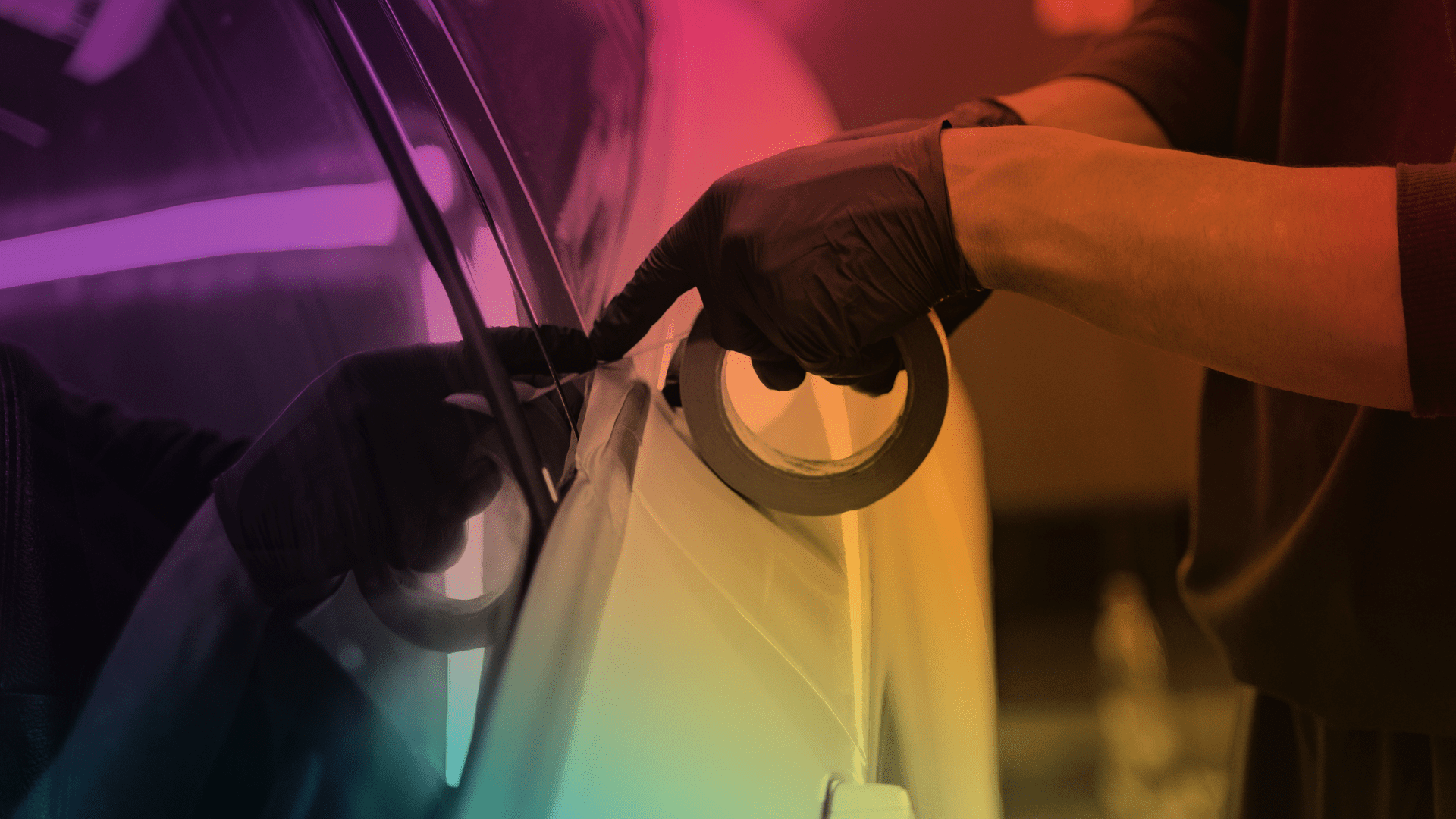 Pessoa com luvas pretas aplicando fita adesiva na janela de um carro, provavelmente para escurecer.