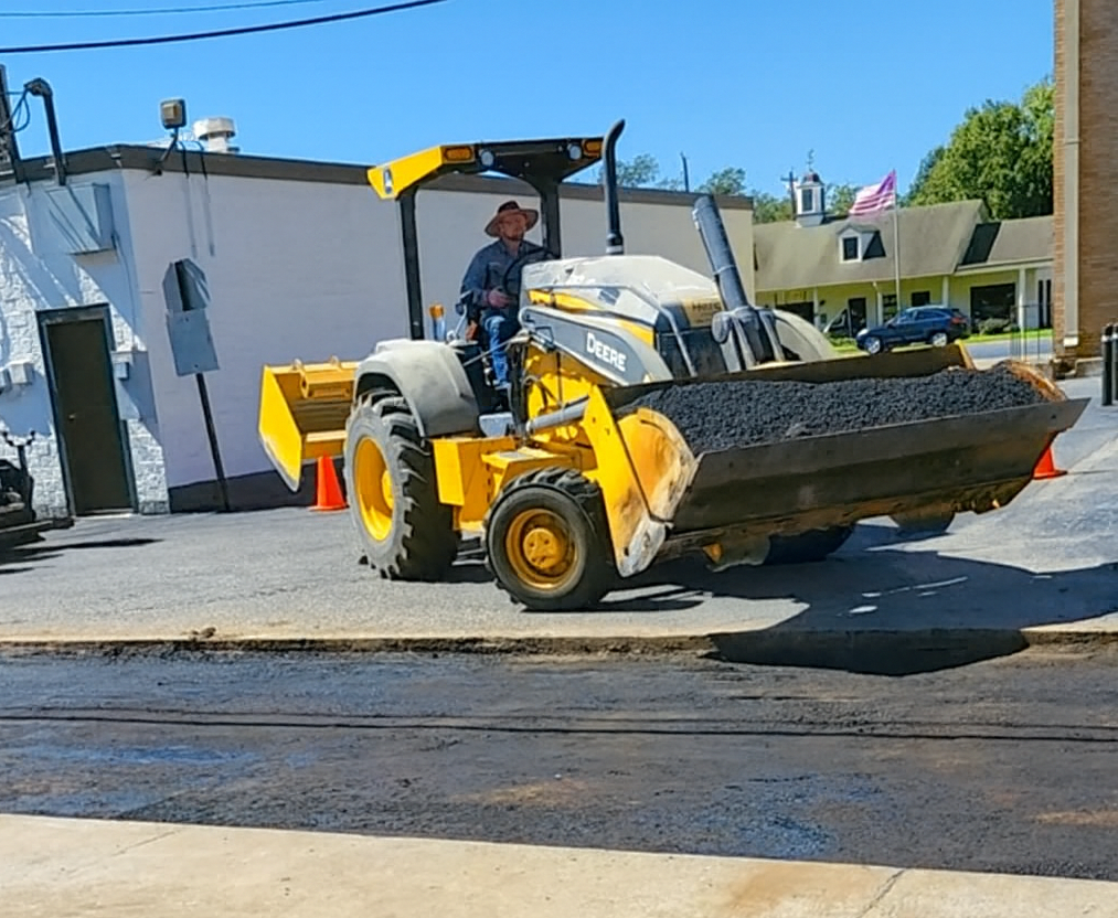 Operating a Yellow Asphalt Roller on A New Driveway — Sealy, TX — Sealy Paving, Inc. Operating a Yellow Asphalt Roller on A New Driveway — Sealy, TX — Sealy Paving, Inc.
