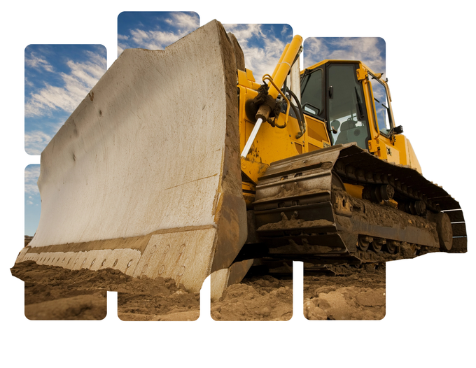 Un bulldozer giallo spinge un grosso blocco di cemento in un cantiere.