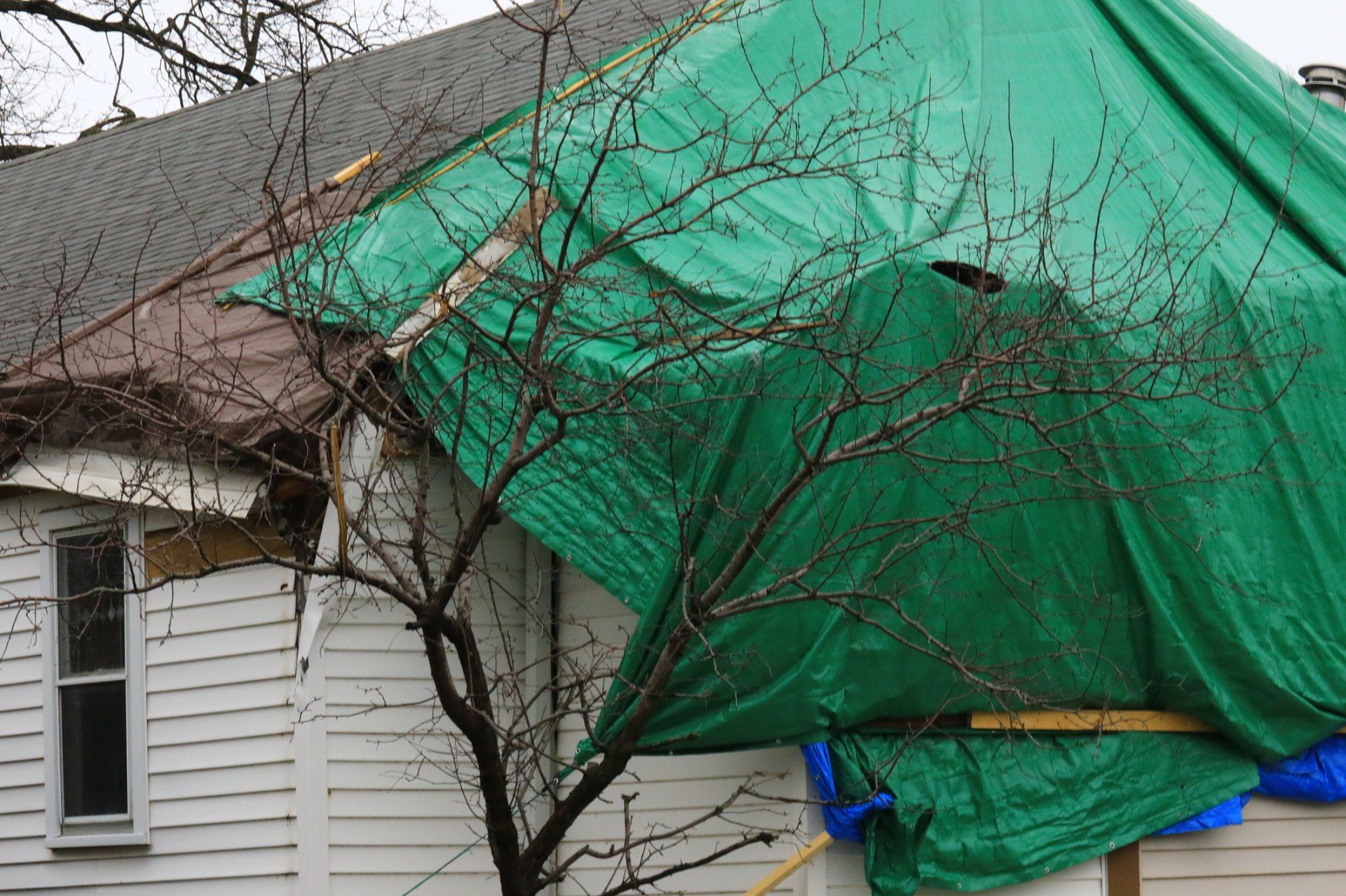 Worker With White Gloves Replacing Gray Tiles - West Liberty, IA - DHG Construction LLC Worker With White Gloves Replacing Gray Tiles - West Liberty, IA - DHG Construction LLC