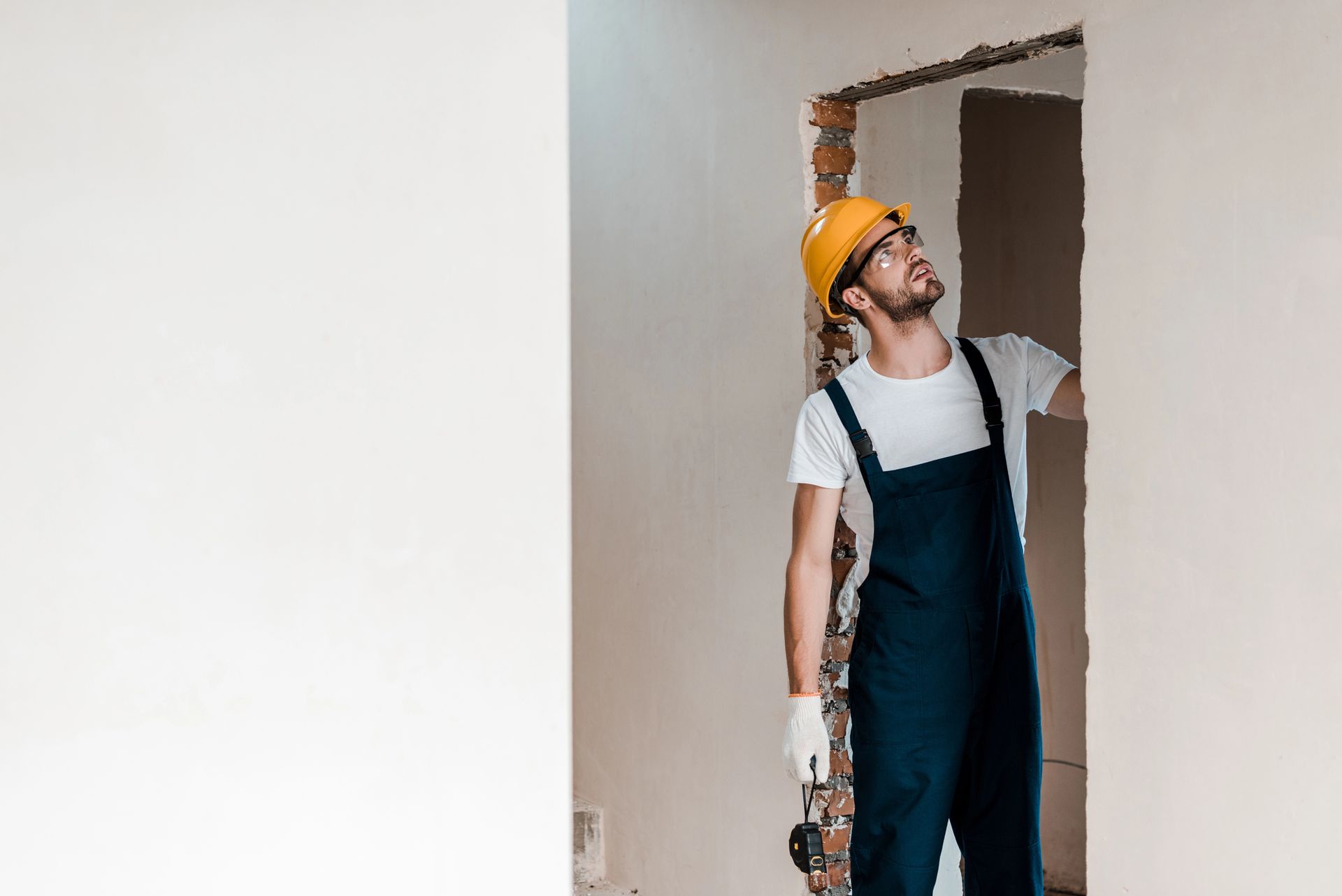 Un trabajador con casco y mono de trabajo está de pie