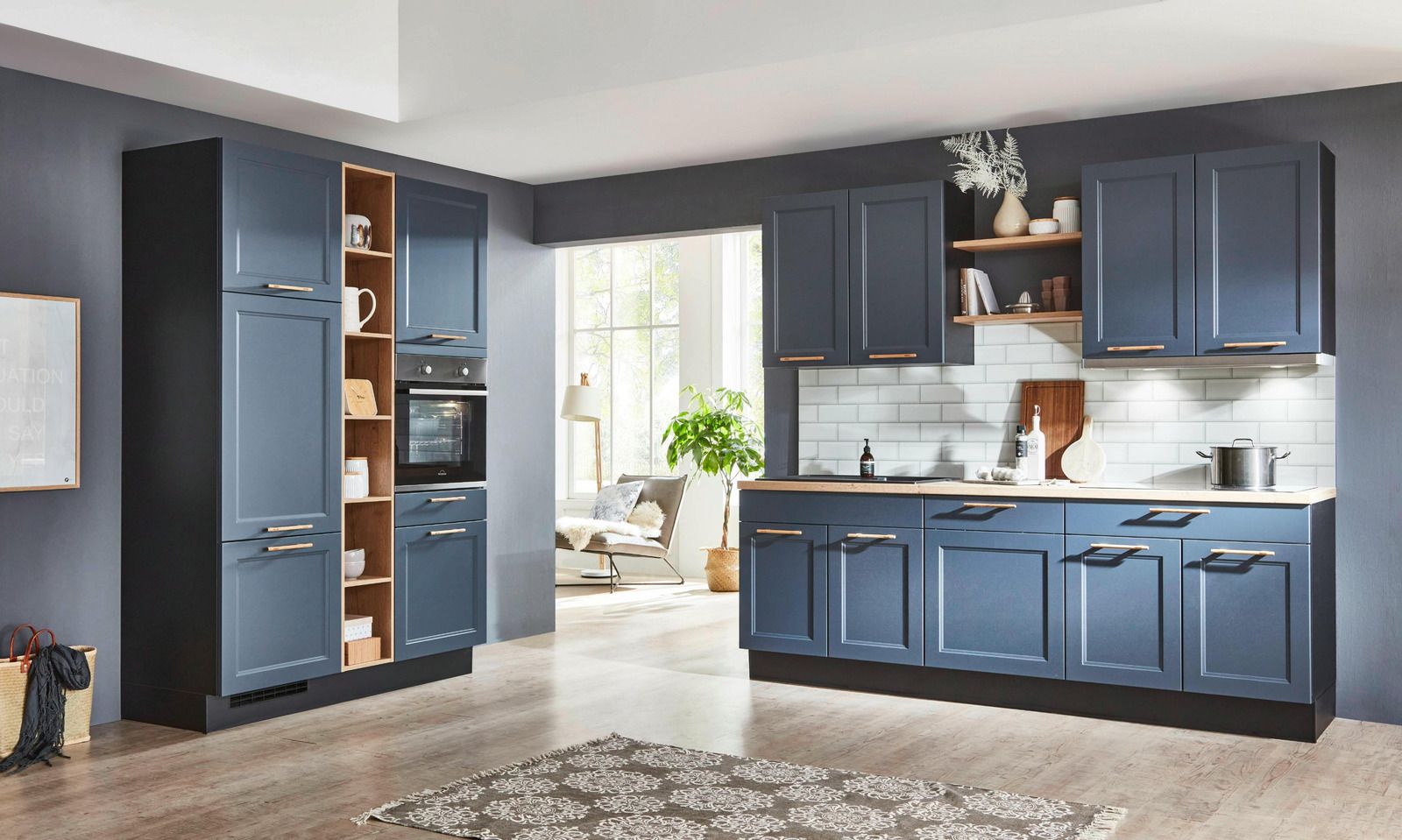 Modern kitchen with blue cabinets, open pantry, and a bright dining area beyond.