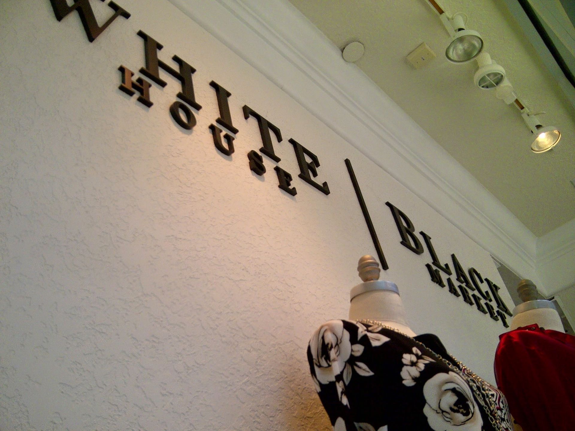 White Brick House sign on a wall above mannequins in a boutique interior