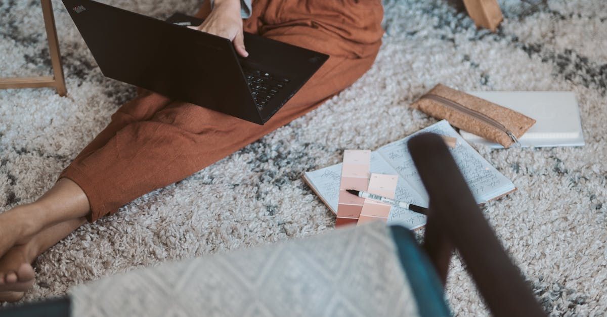 Een vrouw zit op de grond en gebruikt een laptop.