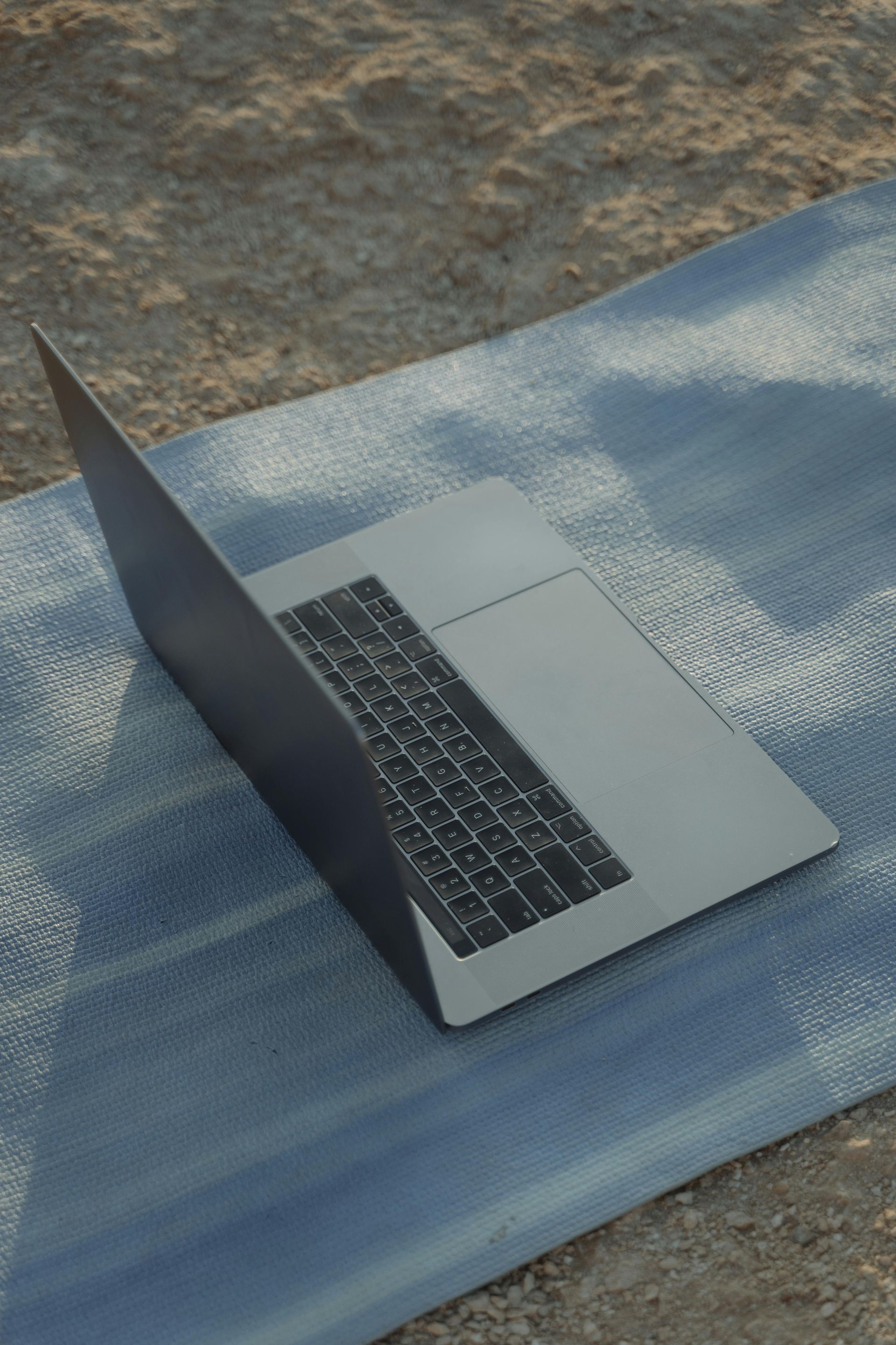 Open laptop op een blauwe yogamat