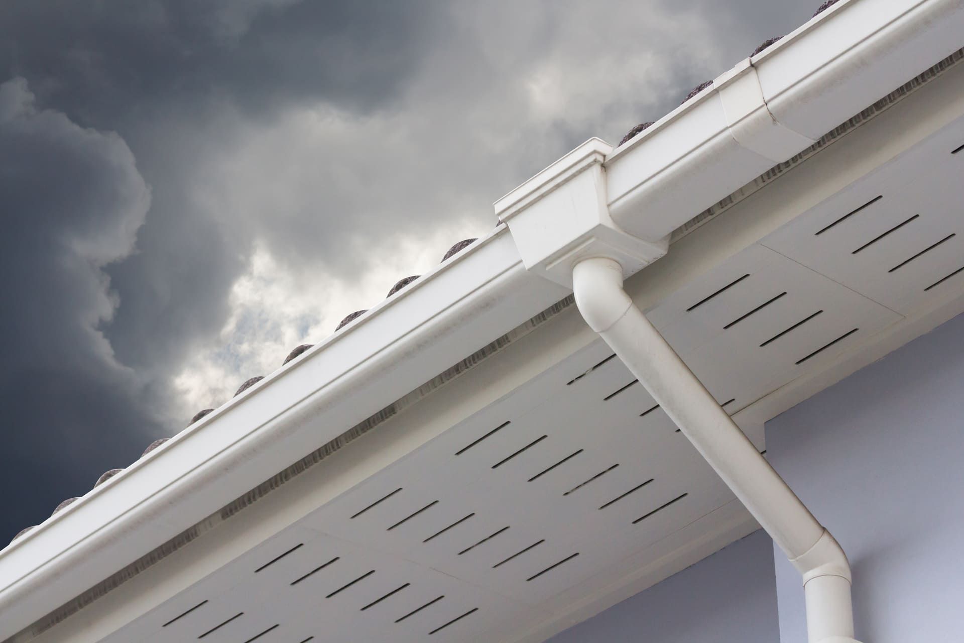 white plastic rain gutter and dark sky. concept : preparing maintenance rain gutter before rainy season