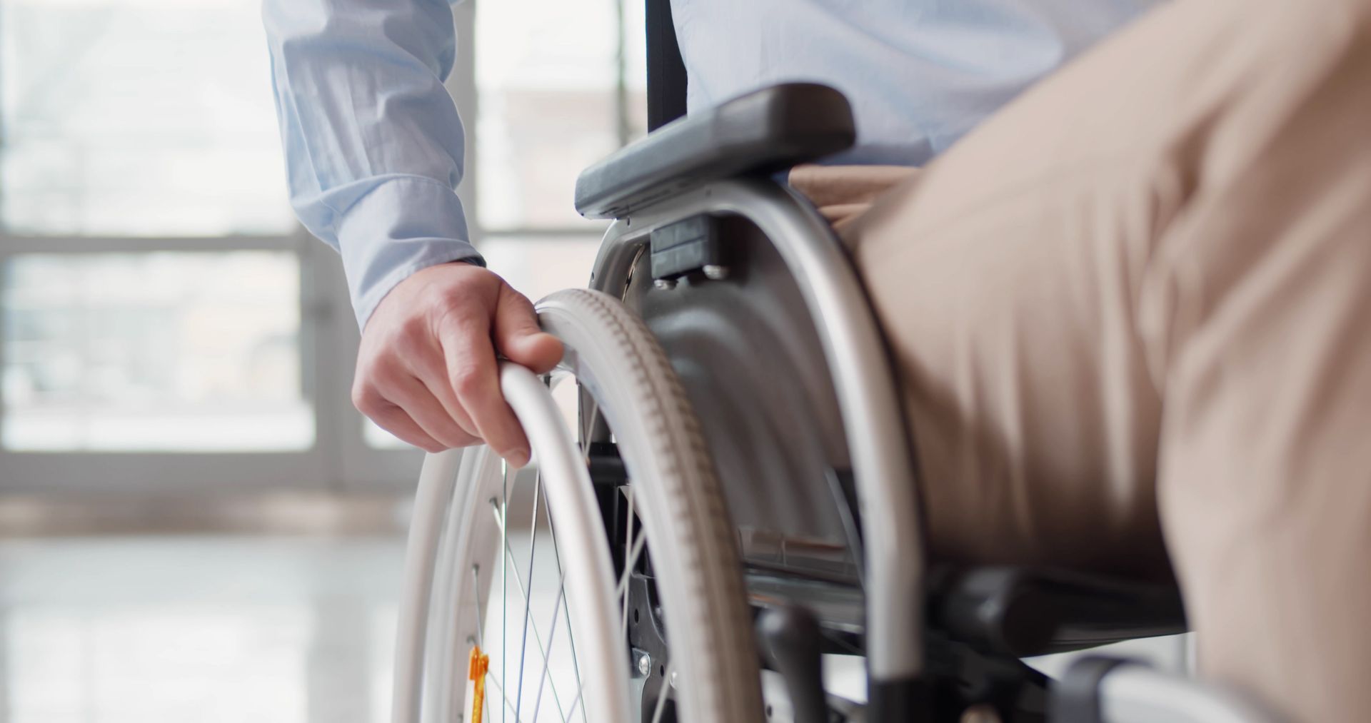 Close up of disabled man riding in wheelchair.