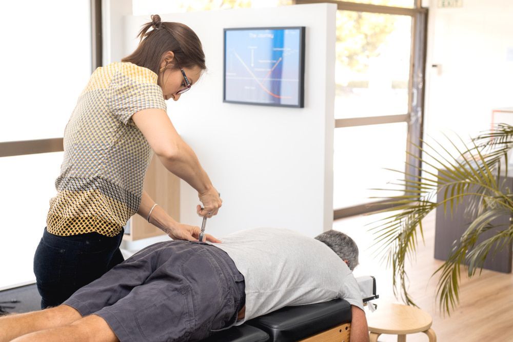 A Woman Is Giving A Man A Massage On A Table — A Myo-Therapy Approach To Remedial & Bowen Therapies In West Gladstone, QLD