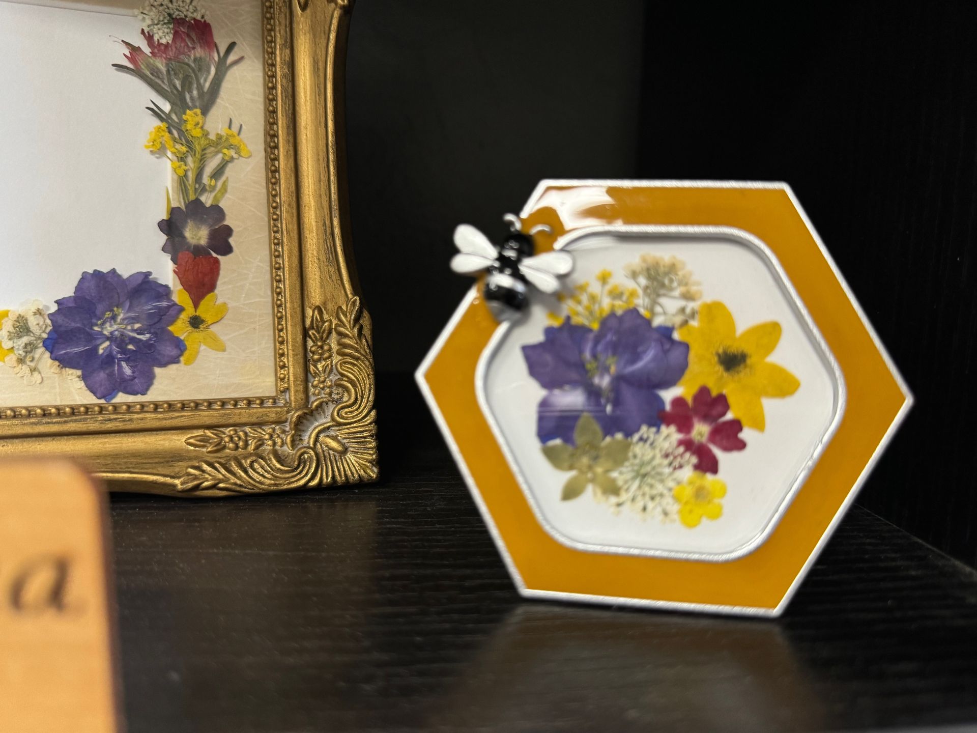 A picture frame with flowers and a bee on it